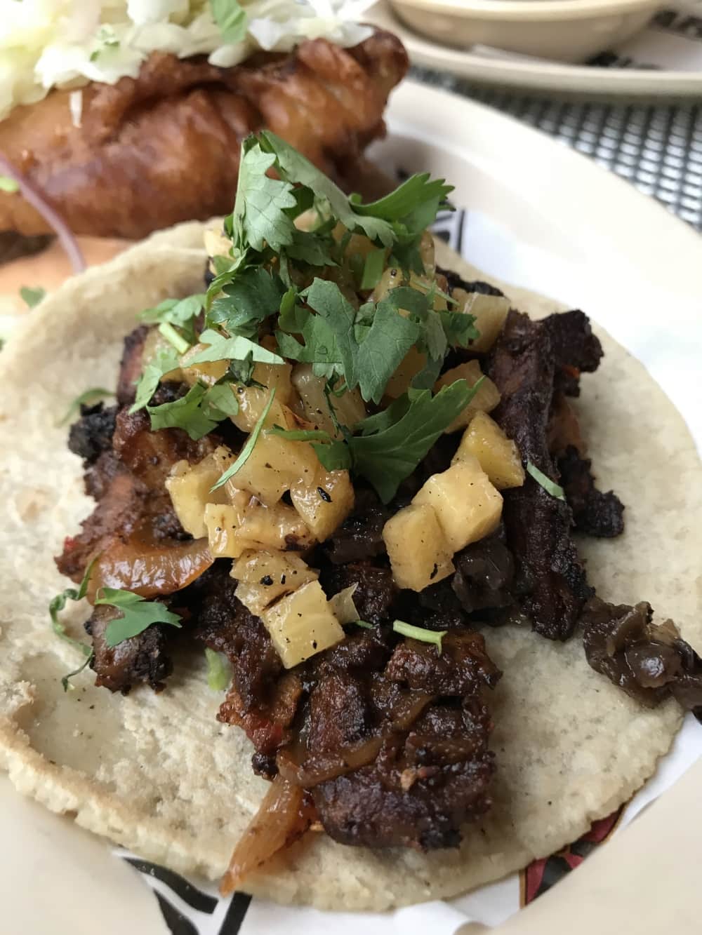 Taco Al Pastor which is a marinated pork shoulder taco topped with grilled pineapple, grilled onions, and cilantro from Big Star Taco in Chicago, IL.